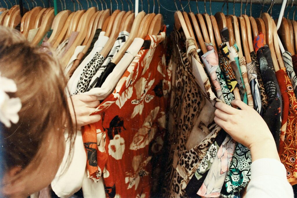 Rack of secondhand clothing in a thrift store, representing accessible and affordable style options.